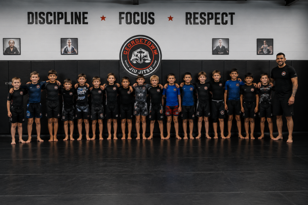 Kids lined up bowing at the start of a jiu jitsu class in Georgetown